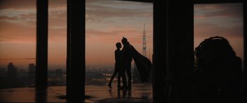 Movie still from “The Batman” (2022), directed by Matt Reeves – Two people dressed as batman and catwoman in front of a city skyline at sunset; Wide shot, Over the shoulder angle