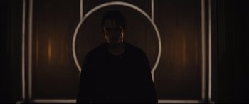 Movie still from “The Batman” (2022), directed by Matt Reeves – A man standing in front of a wall with lights; Medium shot, Low angle