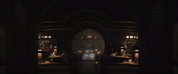 Movie still from “The Batman” (2022), directed by Matt Reeves – A dark room with people sitting at tables and chairs; Extreme Wide shot, High angle