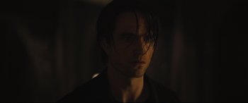 Movie still from “The Batman” (2022), directed by Matt Reeves – A person wearing a black shirt; Close Up shot, Over the shoulder angle