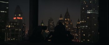 Movie still from “The Batman” (2022), directed by Matt Reeves – Two people sitting on a ledge in front of a city skyline at night; Extreme Wide shot, Low angle