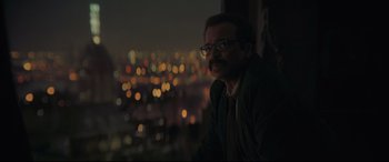 Movie still from “The Batman” (2022), directed by Matt Reeves – A man with glasses is looking out of a window at night; Close Up shot, Low angle