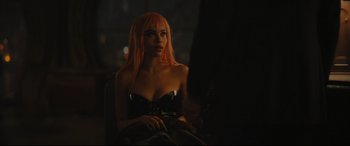 Movie still from “The Batman” (2022), directed by Matt Reeves – A woman with pink hair sitting in front of a window at night; Medium shot, Over the shoulder angle