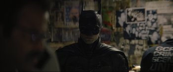 Movie still from “The Batman” (2022), directed by Matt Reeves – A man wearing a batman mask in front of a wall; Close Up shot, Over the shoulder angle