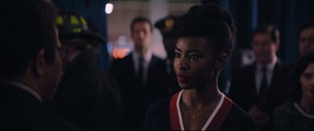 Movie still from “The Batman” (2022), directed by Matt Reeves – A woman standing in front of a group of people; Close Up shot, Over the shoulder angle