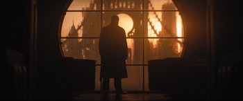 Movie still from “The Batman” (2022), directed by Matt Reeves – A man standing in front of a large window; Wide shot, Low angle