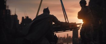 Movie still from “The Batman” (2022), directed by Matt Reeves – A man dressed as batman is standing in front of a city skyline; Wide shot, Low angle