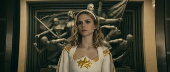 Movie still from “The Boys” (2019), created by Eric Kripke – A woman in a white and gold dress standing in front of a statue; Close Up shot, Low angle
