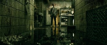Movie still from “The Boys” (2019), created by Eric Kripke – A man standing in a flooded kitchen next to an oven; Wide shot, Low angle