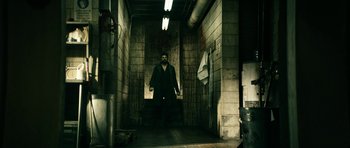 Movie still from “The Boys” (2019), created by Eric Kripke – A man standing in an alley way with his hands in his pockets; Wide shot, High angle