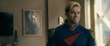 Movie still from “The Boys” (2019), created by Eric Kripke – A man with blonde hair wearing a blue jacket and a red tie; Medium shot, Over the shoulder angle