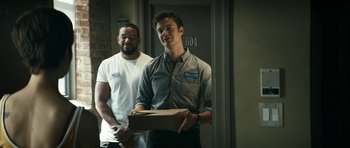 Movie still from “The Boys” (2019), created by Eric Kripke – Two men standing in front of a door holding a box; Medium shot, Over the shoulder angle