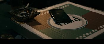 Movie still from “The Boys” (2019), created by Eric Kripke – A cell phone sitting on top of a table; Extreme Close Up shot, Overhead angle