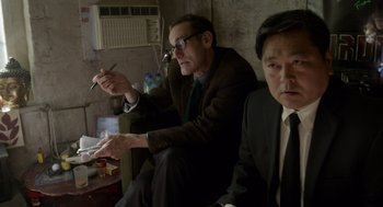 Movie still from “Birdman or (The Unexpected Virtue of Ignorance)” (2014), directed by Alejandro G. Iñárritu – Two men in suits sitting next to each other in a room; Medium shot, High angle