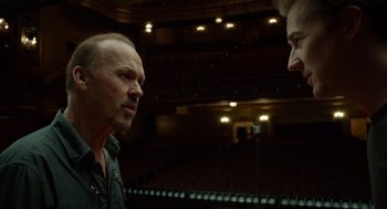 Movie still from “Birdman or (The Unexpected Virtue of Ignorance)” (2014), directed by Alejandro G. Iñárritu – A man and a woman are talking in an auditorium; Medium shot, Over the shoulder angle