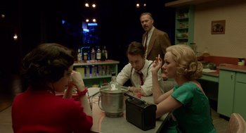 Movie still from “Birdman or (The Unexpected Virtue of Ignorance)” (2014), directed by Alejandro G. Iñárritu – A group of people sitting around a table; Medium shot, Over the shoulder angle