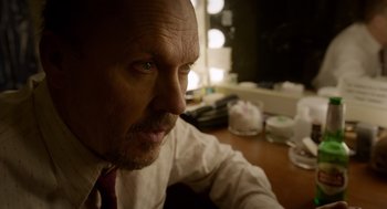 Movie still from “Birdman or (The Unexpected Virtue of Ignorance)” (2014), directed by Alejandro G. Iñárritu – A person sitting at a table; Close Up shot, Low angle
