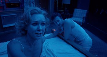 Movie still from “Birdman or (The Unexpected Virtue of Ignorance)” (2014), directed by Alejandro G. Iñárritu – A man and a woman laying on a bed in the dark; Medium shot, Over the shoulder angle