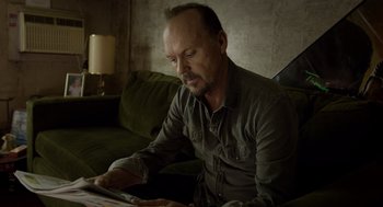Movie still from “Birdman or (The Unexpected Virtue of Ignorance)” (2014), directed by Alejandro G. Iñárritu – A man sitting on a couch looking at a tablet computer; Medium shot, Over the shoulder angle