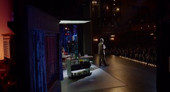 Movie still from “Birdman or (The Unexpected Virtue of Ignorance)” (2014), directed by Alejandro G. Iñárritu – A man standing on a stage in front of an audience; Extreme Wide shot, Over the shoulder angle