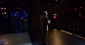 Movie still from “Birdman or (The Unexpected Virtue of Ignorance)” (2014), directed by Alejandro G. Iñárritu – A man standing on a stage in front of an audience; Wide shot, Over the shoulder angle