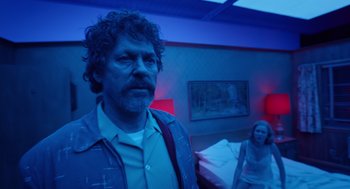 Movie still from “Birdman or (The Unexpected Virtue of Ignorance)” (2014), directed by Alejandro G. Iñárritu – A man and a woman standing in a dark room; Medium shot, Low angle