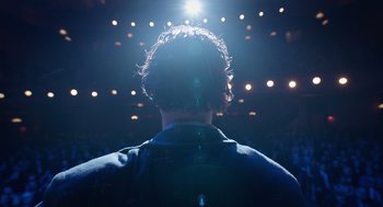 Movie still from “Birdman or (The Unexpected Virtue of Ignorance)” (2014), directed by Alejandro G. Iñárritu – A man is seen from the back of the audience; Medium shot, Low angle