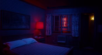 Movie still from “Birdman or (The Unexpected Virtue of Ignorance)” (2014), directed by Alejandro G. Iñárritu – A bed room with a bed and a window at night time; Wide shot, High angle