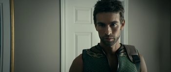 Movie still from “The Boys” (2019), created by Eric Kripke – A person wearing a vest near a door; Close Up shot, Over the shoulder angle