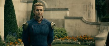 Movie still from “The Boys” (2019), created by Eric Kripke – A man in a blue and red outfit holding a kite; Medium shot, Over the shoulder angle