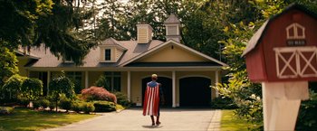 Movie still from “The Boys” (2019), created by Eric Kripke – A man dressed as captain america in front of a house; Wide shot, Low angle