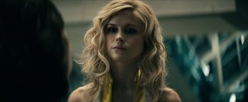 Movie still from “The Boys” (2019), created by Eric Kripke – A woman with long blonde hair wearing a yellow necklace; Close Up shot, Over the shoulder angle