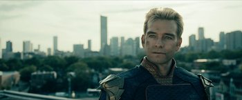 Movie still from “The Boys” (2019), created by Eric Kripke – A person wearing a costume near a city; Close Up shot, Over the shoulder angle