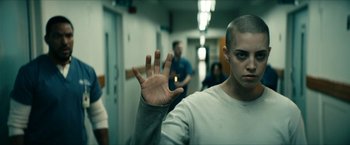 Movie still from “The Boys” (2019), created by Eric Kripke – A man with shaved head is holding his hand up in the air; Medium shot, Over the shoulder angle