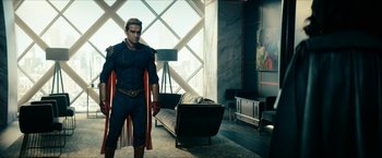 Movie still from “The Boys” (2019), created by Eric Kripke – A man dressed as a superhero standing in a living room; Wide shot, Over the shoulder angle