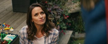 A beautiful woman with long brown hair wearing a plaid shirt