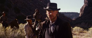 Movie still from “3:10 to Yuma” (2007), directed by James Mangold – A man in a cowboy hat standing in front of another man in a cowboy hat; Medium shot, Low angle
