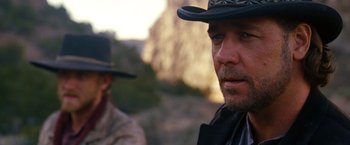 Movie still from “3:10 to Yuma” (2007), directed by James Mangold – A man in a cowboy hat is looking at the camera; Close Up shot, Over the shoulder angle