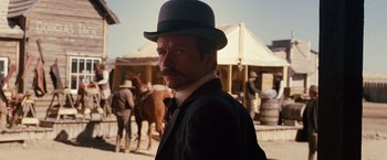 Movie still from “3:10 to Yuma” (2007), directed by James Mangold – A man in a top hat standing next to a horse; Close Up shot, Low angle