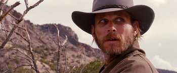 Movie still from “3:10 to Yuma” (2007), directed by James Mangold – A person wearing a hat with mountains in the background; Close Up shot, Low angle