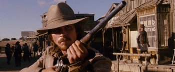 Movie still from “3:10 to Yuma” (2007), directed by James Mangold – A man holding a rifle in his hands; Close Up shot, Low angle