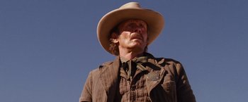 Movie still from “3:10 to Yuma” (2007), directed by James Mangold – A man wearing a cowboy hat standing in a field; Close Up shot, Low angle