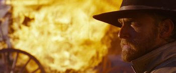 Movie still from “3:10 to Yuma” (2007), directed by James Mangold – A man in a cowboy hat standing in front of a fire; Close Up shot, Low angle