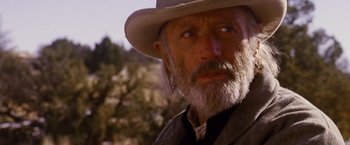 Movie still from “3:10 to Yuma” (2007), directed by James Mangold – An old man with a gray beard wearing a white hat; Close Up shot, Low angle