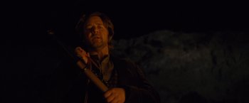 Movie still from “3:10 to Yuma” (2007), directed by James Mangold – A man holding a baseball bat while standing in the dark; Medium shot, Low angle