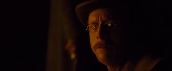 Movie still from “3:10 to Yuma” (2007), directed by James Mangold – A person wearing glasses and a hat; Close Up shot, Over the shoulder angle
