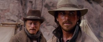 Movie still from “3:10 to Yuma” (2007), directed by James Mangold – Two men in hats and jackets standing next to each other; Close Up shot, Over the shoulder angle