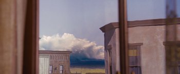 Movie still from “3:10 to Yuma” (2007), directed by James Mangold – A view of a cloudy sky from a window of an old building; Extreme Wide shot, Low angle