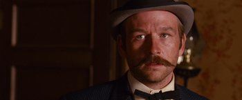 Movie still from “3:10 to Yuma” (2007), directed by James Mangold – A person wearing a hat and a suit; Close Up shot, Over the shoulder angle