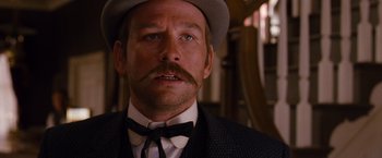 Movie still from “3:10 to Yuma” (2007), directed by James Mangold – A person wearing a suit and hat; Close Up shot, Low angle